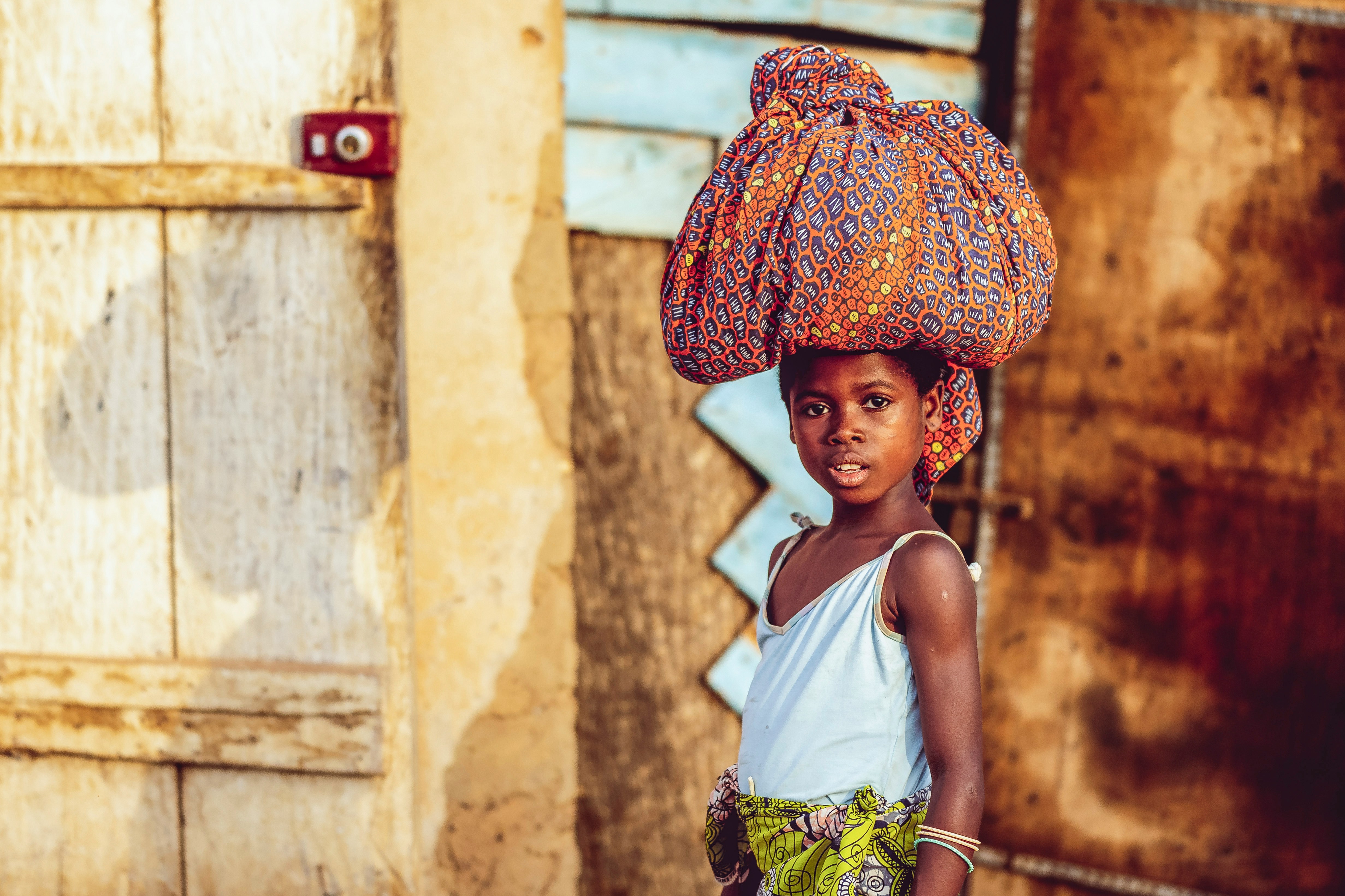 Young girl carrying bag on her head